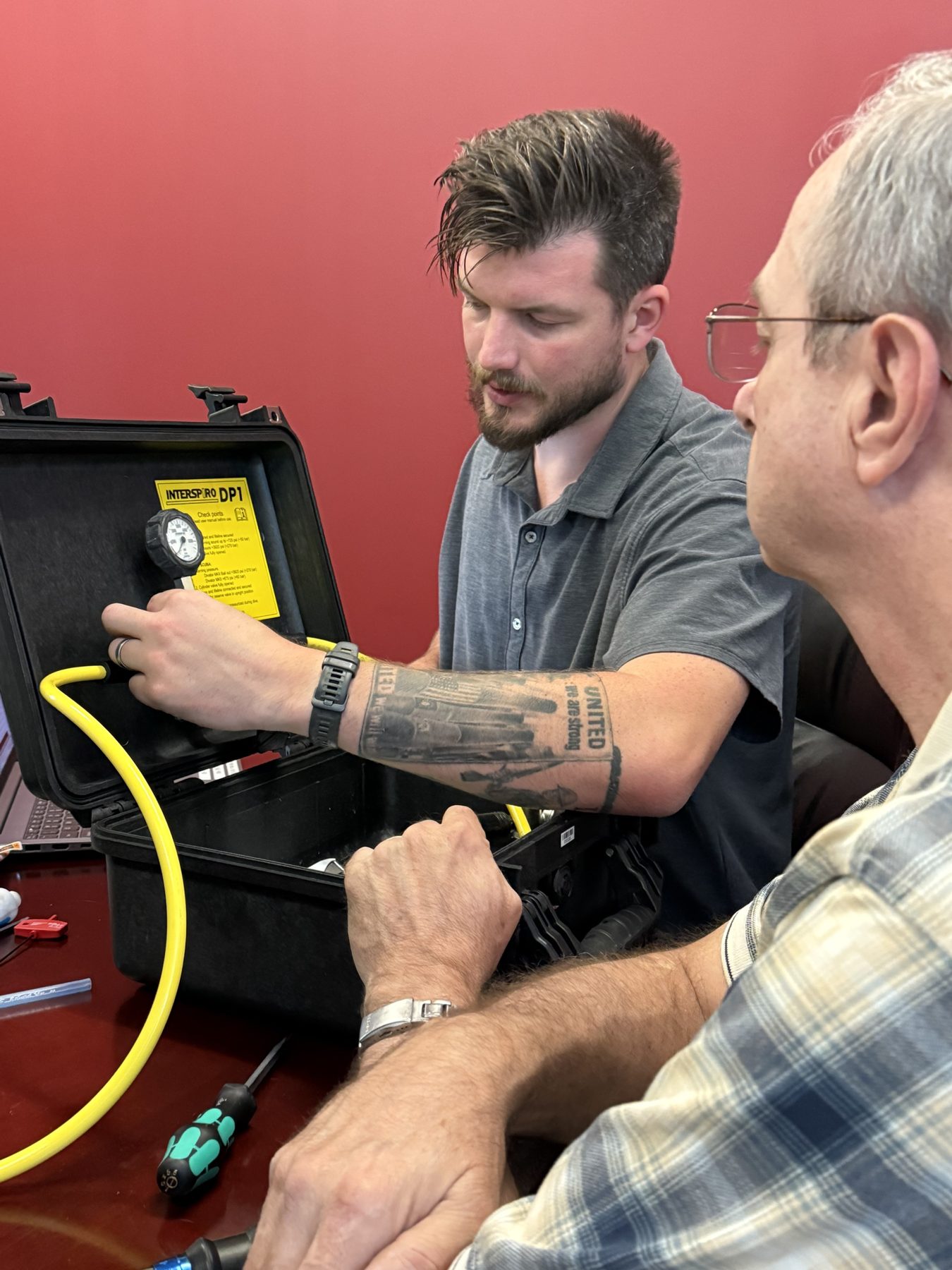 Connecting the hose to the Interspiro DP-1 surface unit during a hands-on session