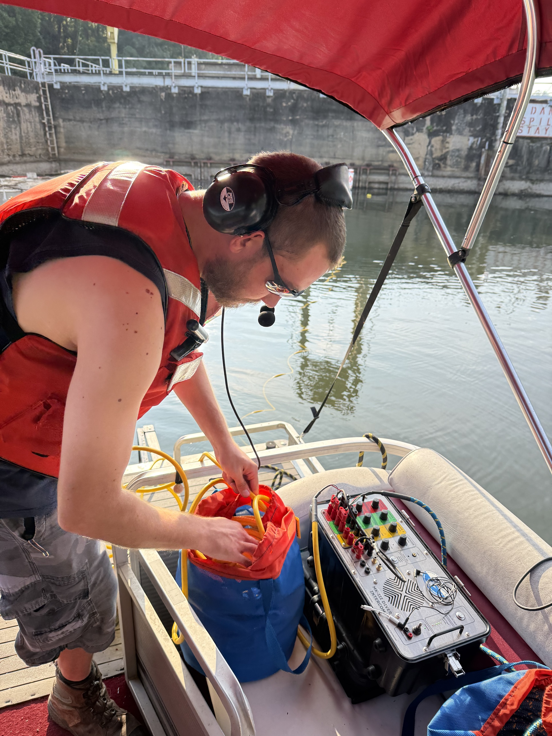 Dive tender wearing an OTS headset managing the diver tether and OTS MK-III intercom on the pontoon at Lake Adger