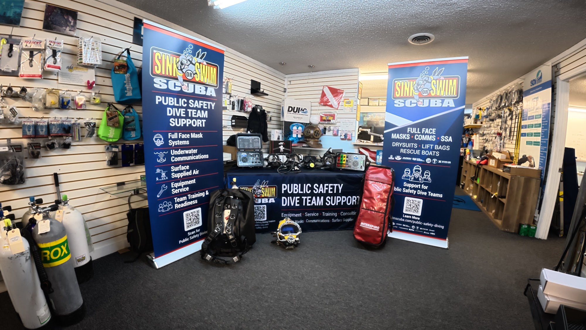 Inside Sink or Swim Scuba, a family-owned dive shop near Charlotte, NC, with gear walls and a public safety dive team support display
