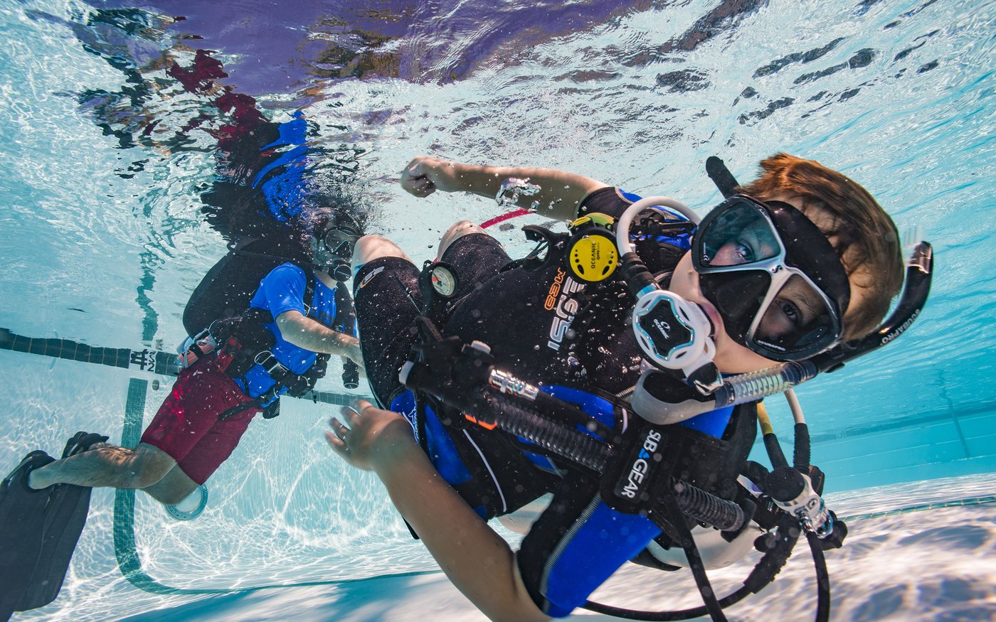 Student diver practicing scuba skills underwater in a training pool